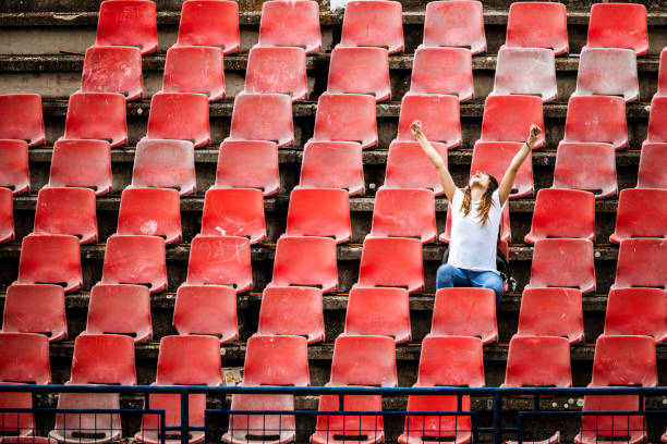 radosna fanka sportu świętuje sukces swojej drużyny na stadionie. - stadium empty seat women zdjęcia i obrazy z banku zdjęć