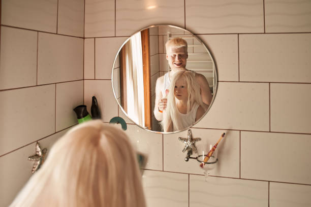 istock Man doing hairstyle for his little daughter at the bathroom while smiling 1325185183