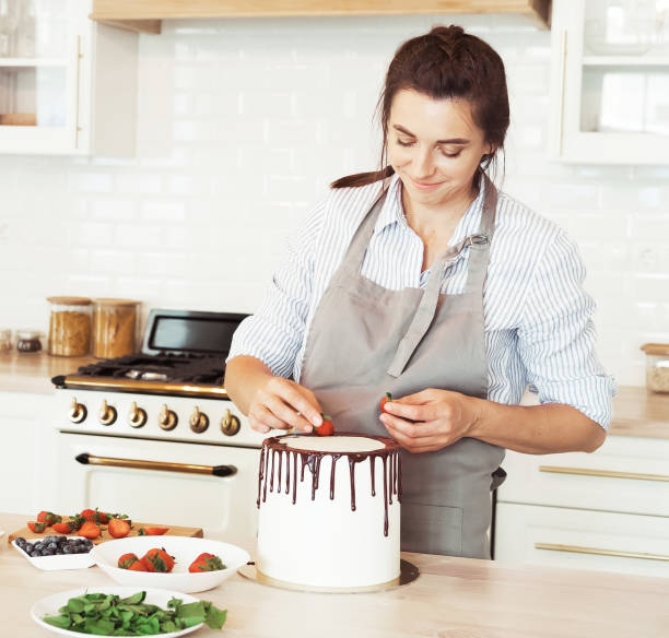 istock Pastry chef decorates the cake with berries 1325186001