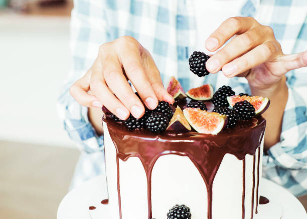 istock Pastry chef decorates the cake with fresh berries and figs 1325186874
