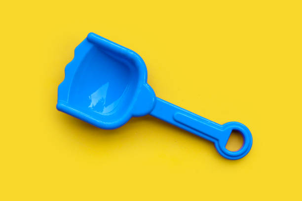 istock Plastic toy, shovel on yellow surface. 1325189076