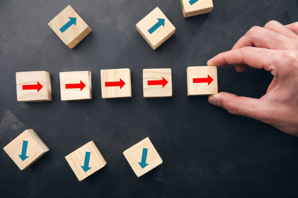 istock Hand holding arrows on wooden cube 1325190496