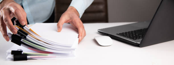istock man holding business paper file with laptop computer 1325190543
