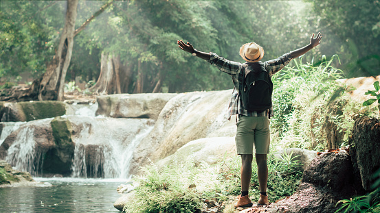 African man traveler standing on the water fall  with smile and happy.16:9 style