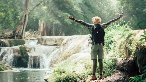 african man traveler standing on the water fall  with smile and happy.16:9 style - tourism imagens e fotografias de stock