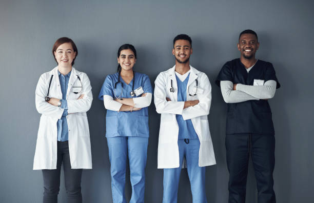 istock Shot of a group of doctors standing against a grey background at work 1325190894
