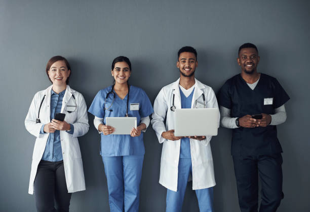 istock Shot of a group of doctors standing against a grey background at work 1325190904