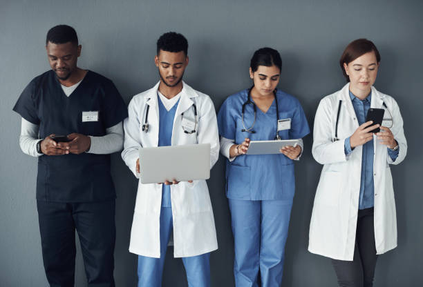 istock Shot of a group of doctors standing against a grey background at work 1325190907