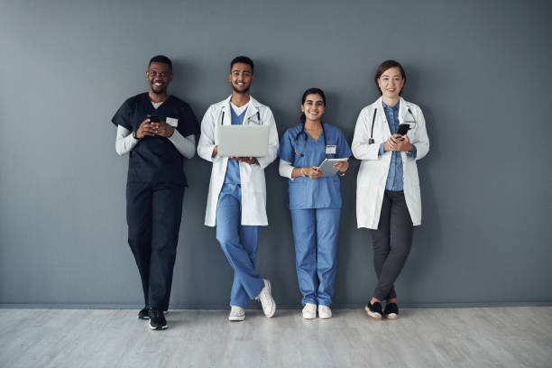 istock Shot of a group of doctors standing against a grey background at work 1325190913