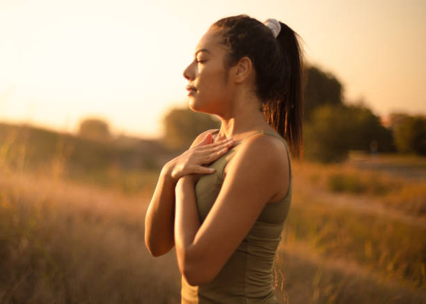 mujer joven practicando yoga de respiración. - cuidado del cuerpo fotografías e imágenes de stock