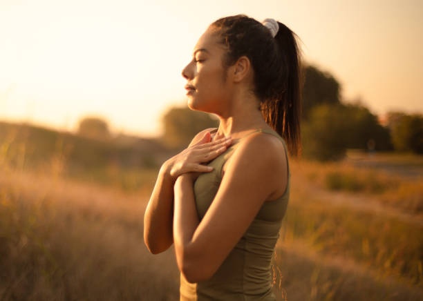 Young woman practicing breathing yoga. African young woman in nature working yoga. tranquility stock pictures, royalty-free photos & images