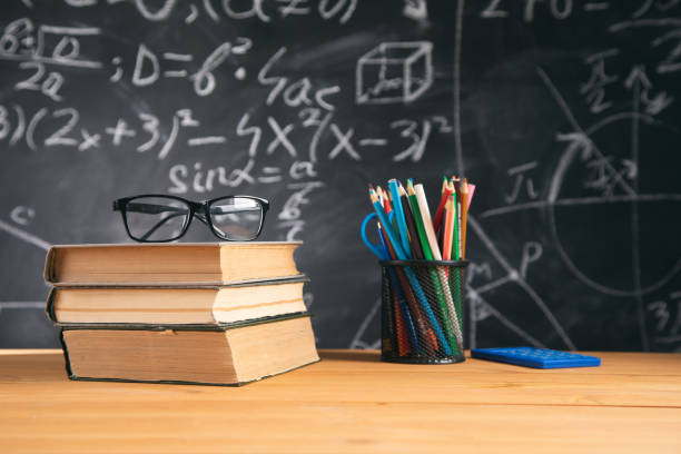 istock glasses on book with pencils on blackboard 1325193372