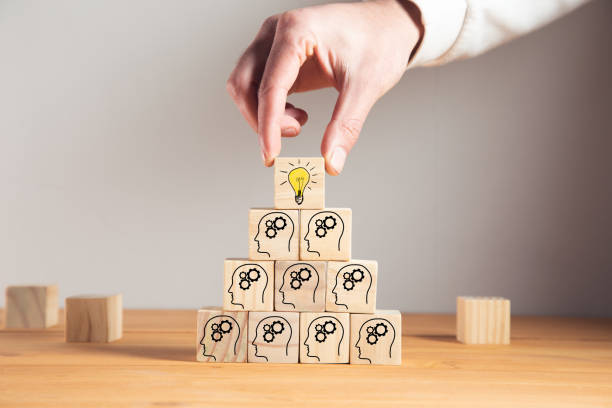 istock holding wooden cube block with head human symbol and light bulb icon 1325193398