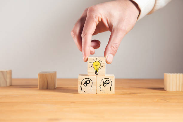 istock holding wooden cube block with head human symbol and light bulb icon 1325193403
