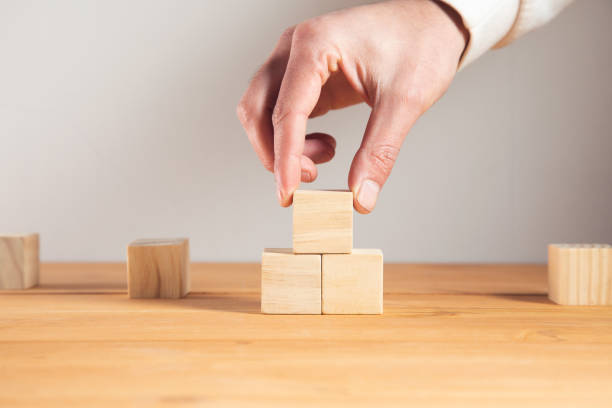 istock business man holding wooden cubes 1325193442