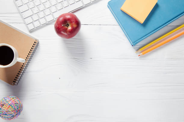 istock cup of coffee on notepads with keyboard and apple 1325193457