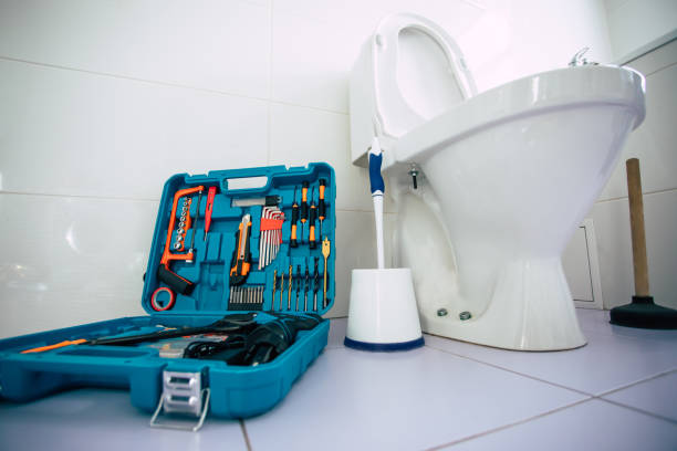 Close up photo of ceramic bowl toilet in domestic bathroom with a box of tools stock photo