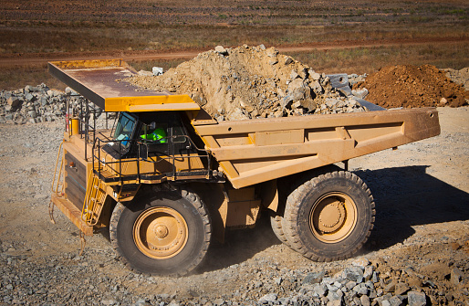 Large yellow truck used in modern lithium mine in Western Australia. A truck transports ore from the open cast mine.