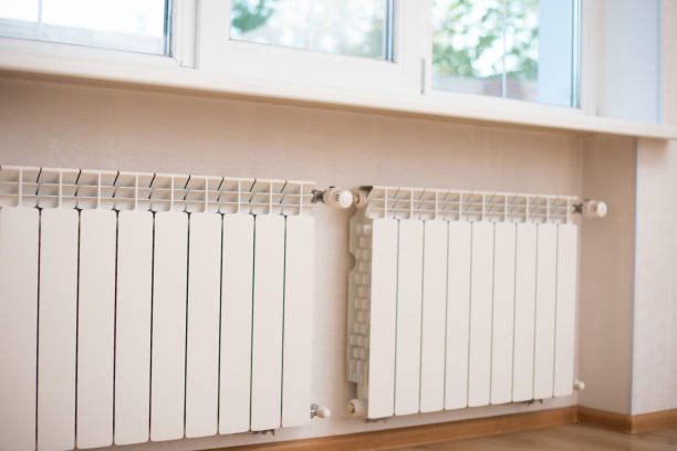 istock Two new white heat radiators hang on the wall under the window 1325195855