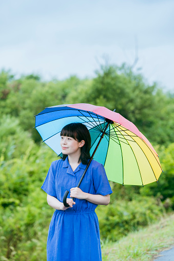 A woman holding a colorful umbrella in the rain