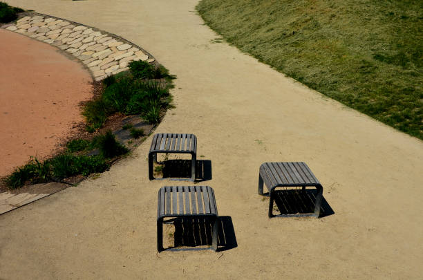 istock stone slabs on the playground form an interesting transition between the surfaces. walkway between a rubber area with table tennis and park benches 1325197285