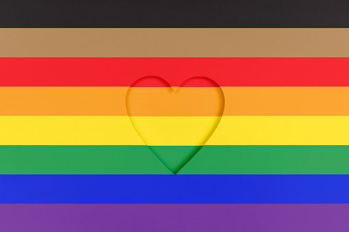 New redesigned LGBTQ pride flag background. Rainbow Printed cardboard with die-cut heart shape. Top view