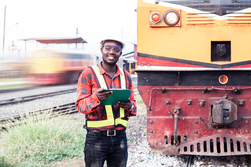 African man engineer looking report of Train Timetables for control a the train on railway