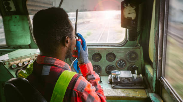 African train driver talking radio communication or walkie talkie in  interior room to control place of train stock photo