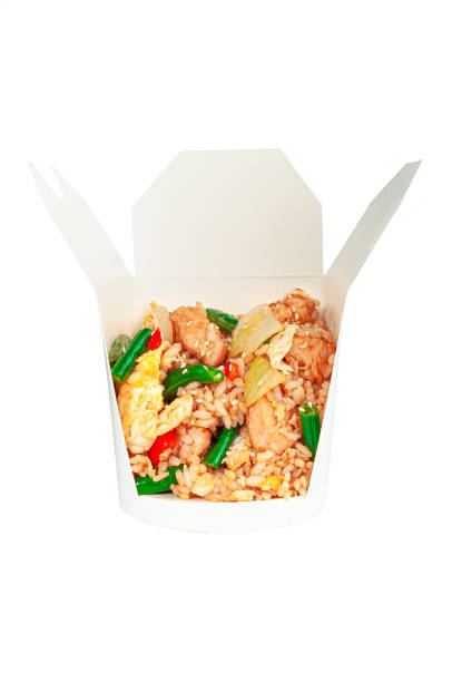 istock Boiled rice with chicken and vegetables. In a shipping box. Ingredients visible. Close-up. White background. Isolated. 1325200974