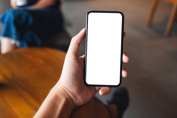 istock a man holding black mobile phone with blank white screen in cafe 1325202096