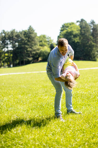 istock Father with daughter having fun on the grass at the park 1325202110