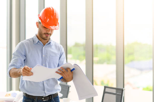istock Portrait of construction engineer manager workers in orange hardhat and looking layout plan. posing standing in office. copy space for text 1325206956