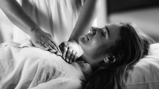 代替療法の概念。クライアントにエネルギーを転送するレイキセラピスト。 - reiki alternative therapy massaging women ストックフォトと画像