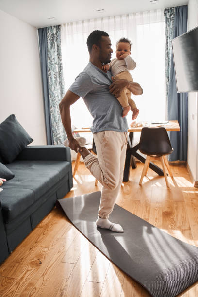 istock Multiracial man holding his son at the hands while meditating and practicing yoga 1325207950