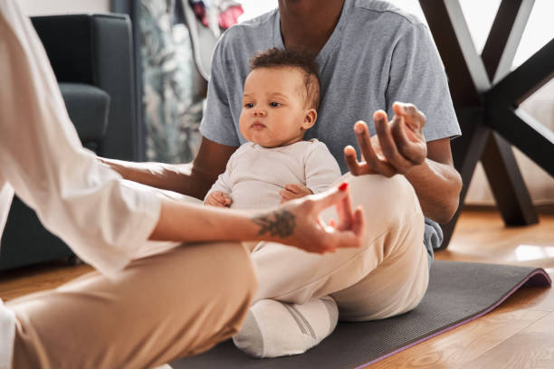 istock Father with crossed legs meditating at home while his son sitting with him 1325208571