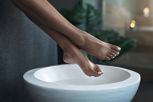 Primer plano de una mujer irreconocible recibiendo un tratamiento para los pies en un spa photo
