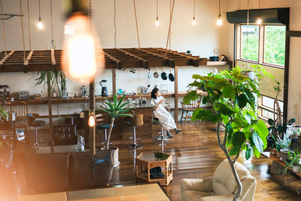 A young woman brewing and drinking coffee A young woman brewing and drinking coffee in a calm atmosphere cafe culture stock pictures, royalty-free photos & images