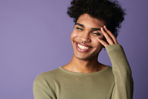 Primer plano de la sonrisa masculina afroamericana con peinado afro. Retrato de guapo joven transgénero photo