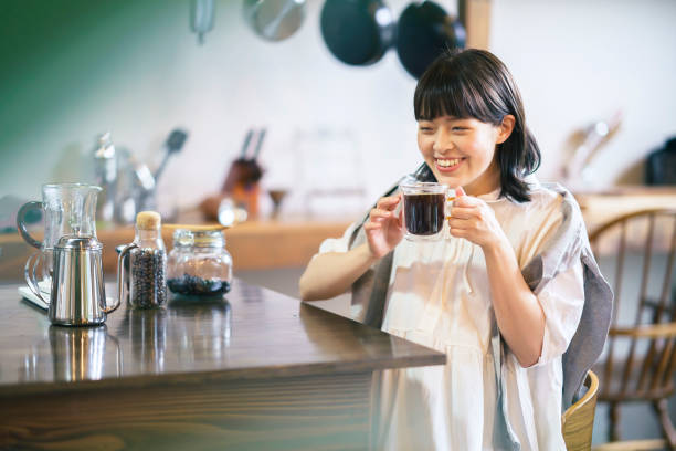 A young woman brewing and drinking coffee A young woman brewing and drinking coffee in a calm atmosphere cafe culture stock pictures, royalty-free photos & images