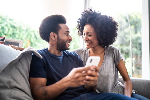 istock Happy couple using smartphone together at home 1325211900