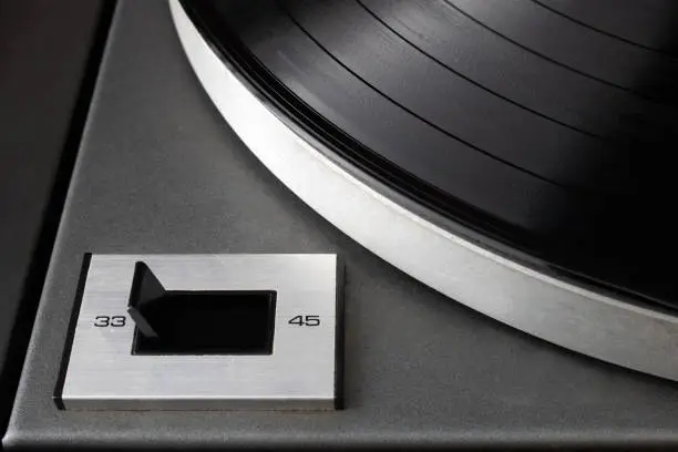 Close-up of speed rotation switch set to 33 RPM on vintage turntable vinyl record player