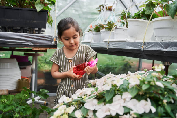 istock Girl examining spray bottle with water while spending time at the garden 1325215700