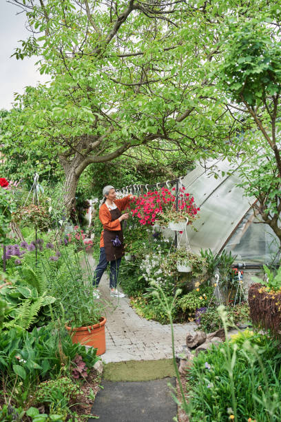 Gardener standing and touching plant while working at the garden center