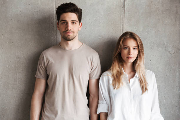 istock Young loving couple standing over grey wall 1325215940