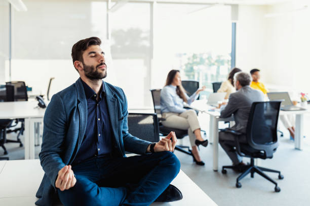 istock Handsome young men meditating on the office desk 1325217917