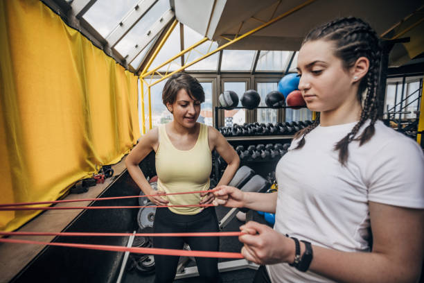 istock Personal trainer assisting a woman in exercise 1325224473