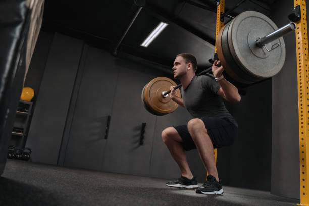 istock Muscular sportsman doing back squat in gym 1325225408