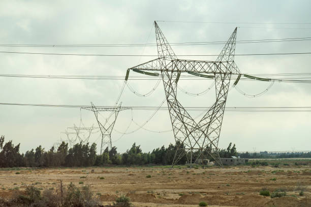 Power lines in the desert against a cloudy sky