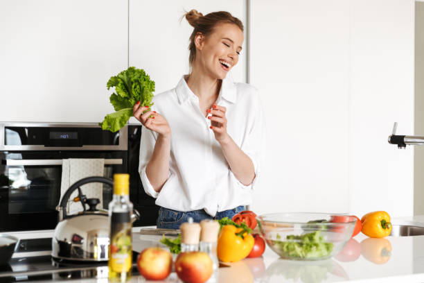 istock Beautiful woman standing in kitchen cooking 1325226868