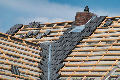 Worker man replace tile of the old roof. Repair roof concept.